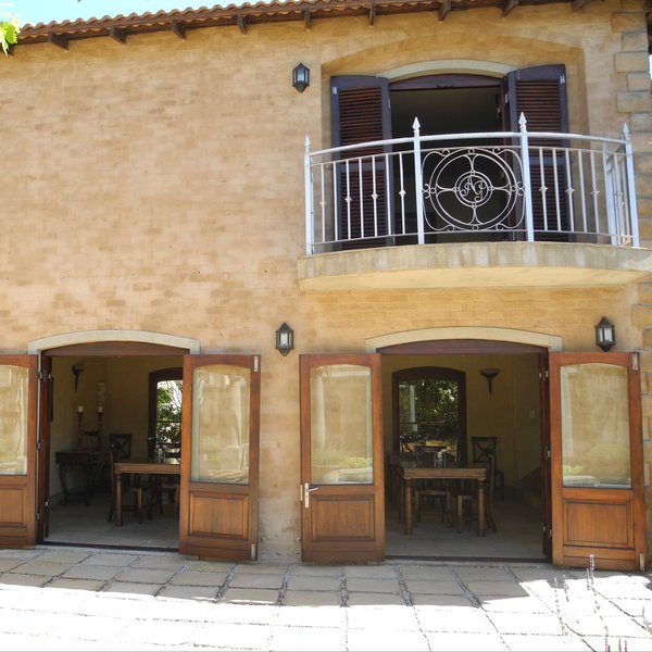 ...with a rustic stone and wrought iron balconied facade.