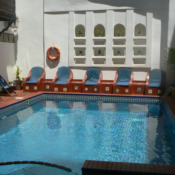 Surrounding the pool is a red-tiled floor and some lovely stone seats molded out of the wall.