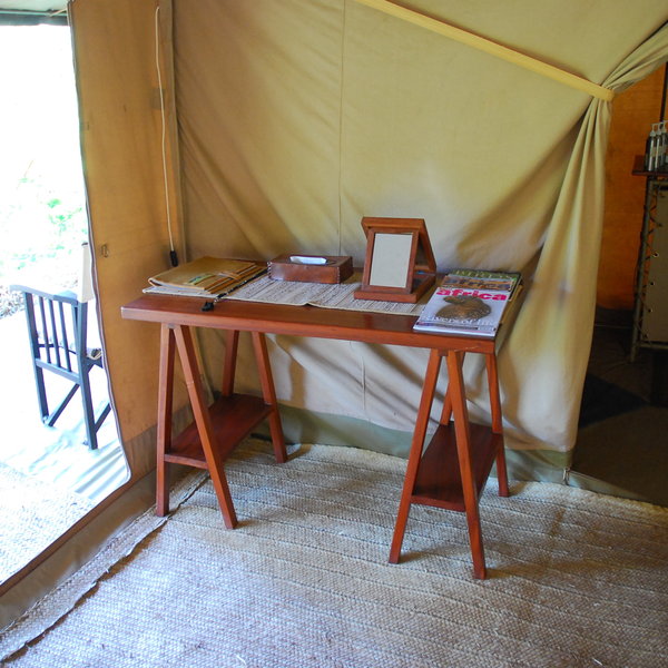 Other furniture consists of a writing table and directors' chairs on the veranda.