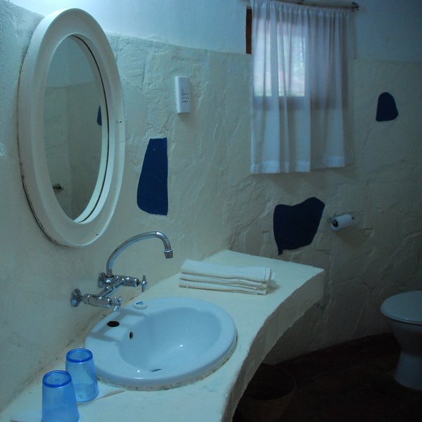 …and a simple en-suite bathroom with a wash basin,…