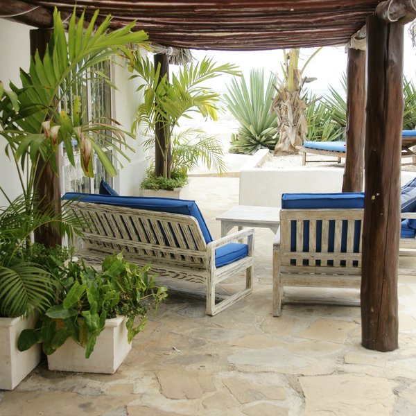 Outside, there is a shaded veranda with a comfortable sitting area.