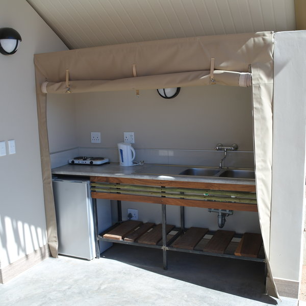 …including a kitchenette which includes a sink, a fridge and a two-plate hob.