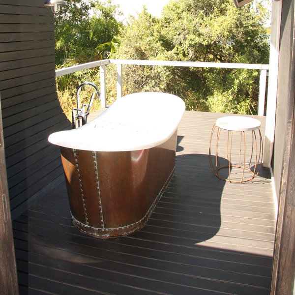 A sliding door opens onto the veranda, where there is a clawfoot bathtub.