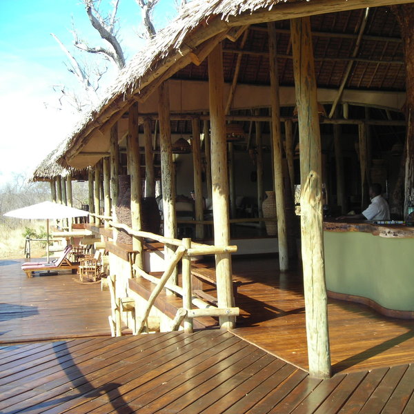 This central area contains a lounge, a dining room, and a shaded pool deck.