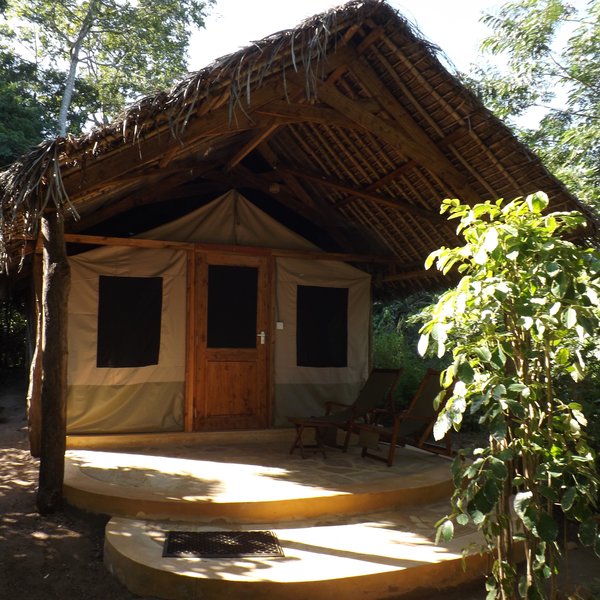 The tents are hung inside thatch Makuti roofs.