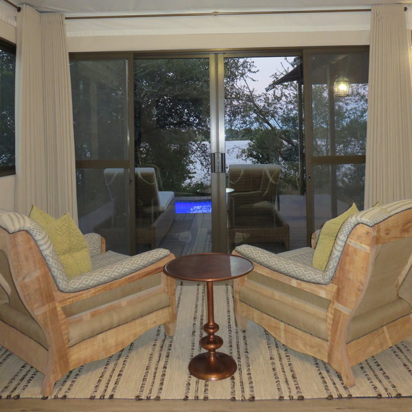 A seating area has comfortable chairs looking out to the deck...