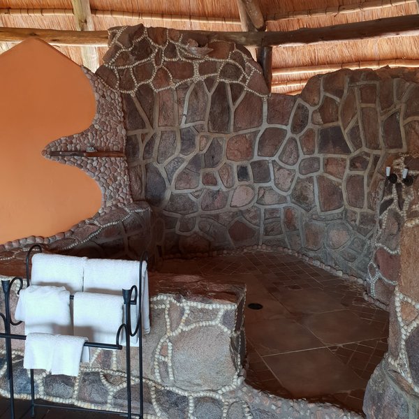 The bathrooms have the same rustic style, with huge waterfall showers.